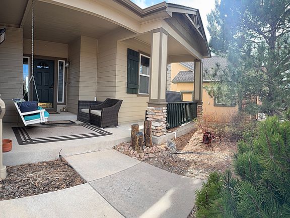 Front entrance with swing and porch seating tucked in the evergreens.