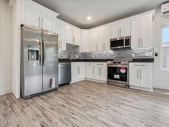 Custom cabinetry with quartz countertops and stainless steel appliances