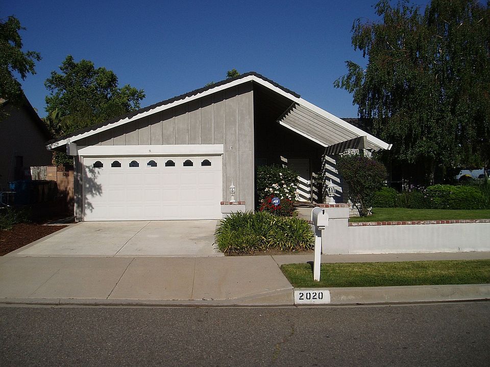Front w/walled off ft yard w/lush green grass
