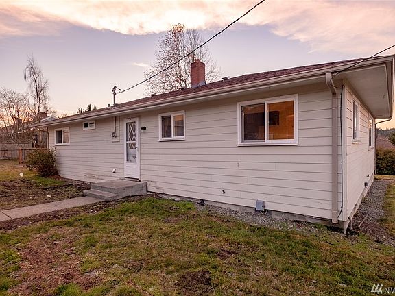 Back yard and entrance to the utility and kitchen spaces. Off to the left is the south side yard w/ concrete pad. 