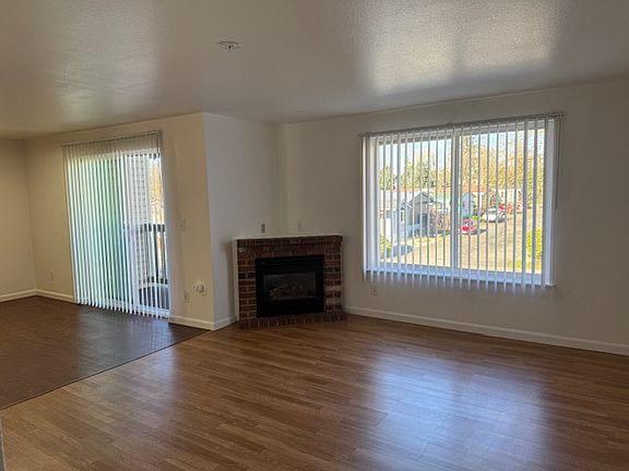 Gas Fireplace insert and sliding door from kitchen to balcony. Blinds on all windows throughout this apartment home.