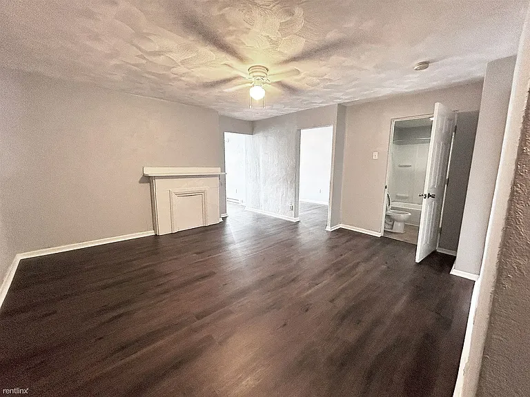Room immediately after living room showing doorway to bathroom and kitchen