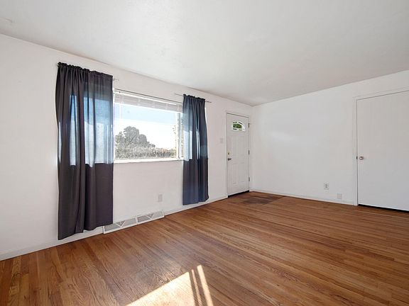 Large living room with coat closet and hardwood floors.