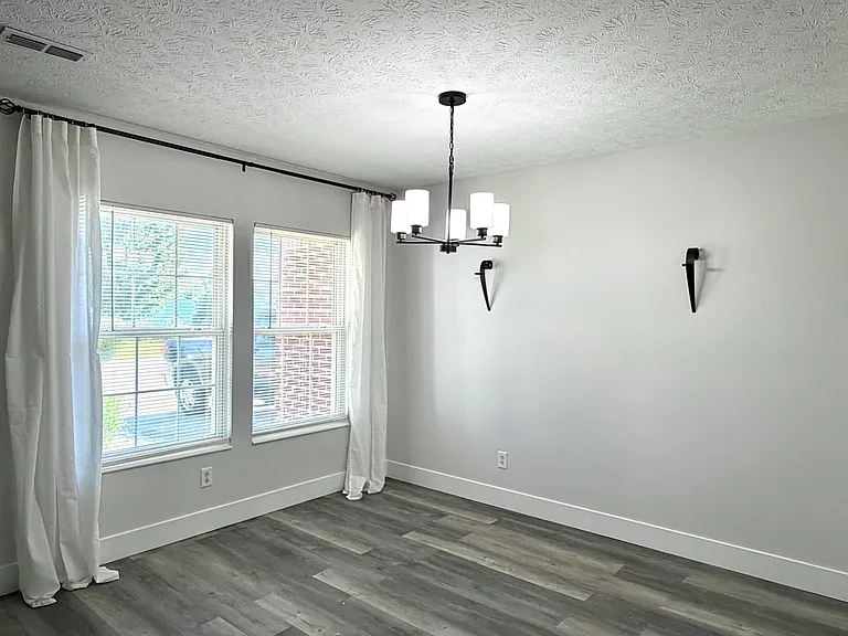 Formal dining room, with large windows and window treatments