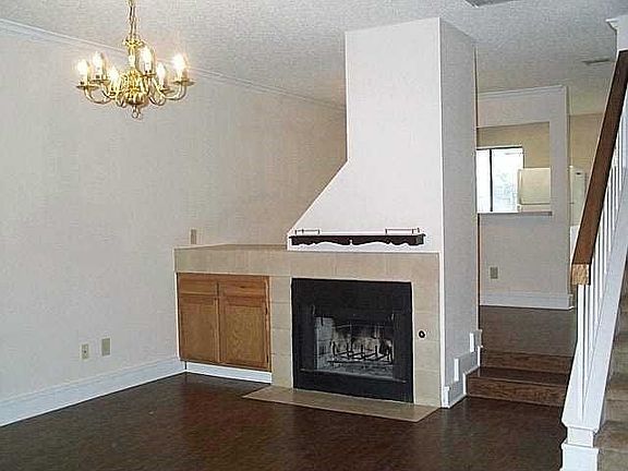 Woodburning fireplace in living room with parquet hardwood f