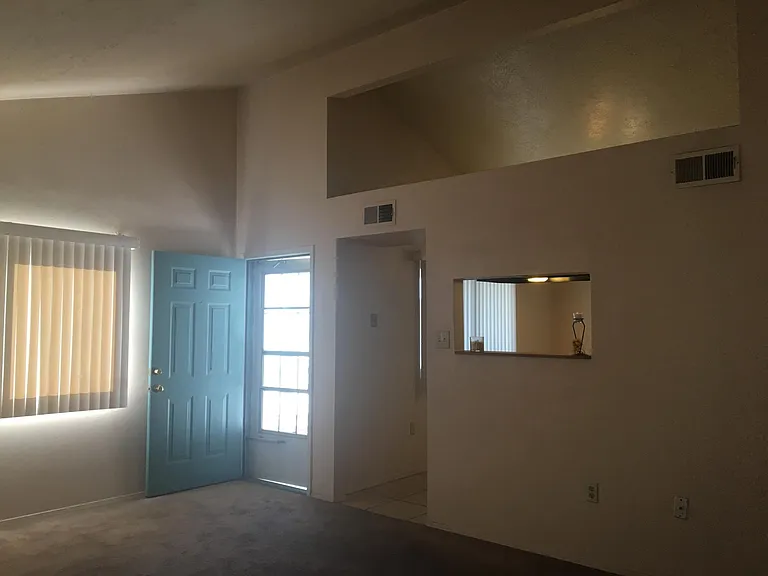 View of living room with pass-through opening into kitchen.
PS - carpet has been replaced by vinyl plank flooring.
