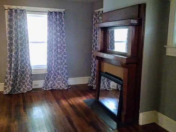 Living Room with oak mantle and leaded glass window.