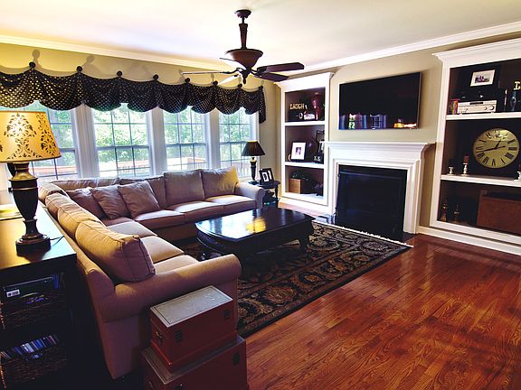 Living room features built-in shelves, moldings around Gas fireplace.