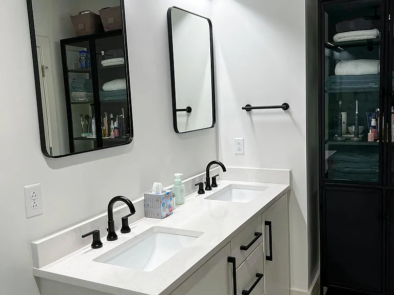 Dual vanity with storage and quartz counters.