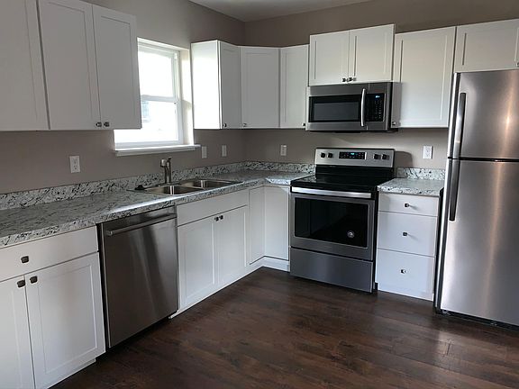 Updated kitchen with white shaker cabinets and stainless appliances.