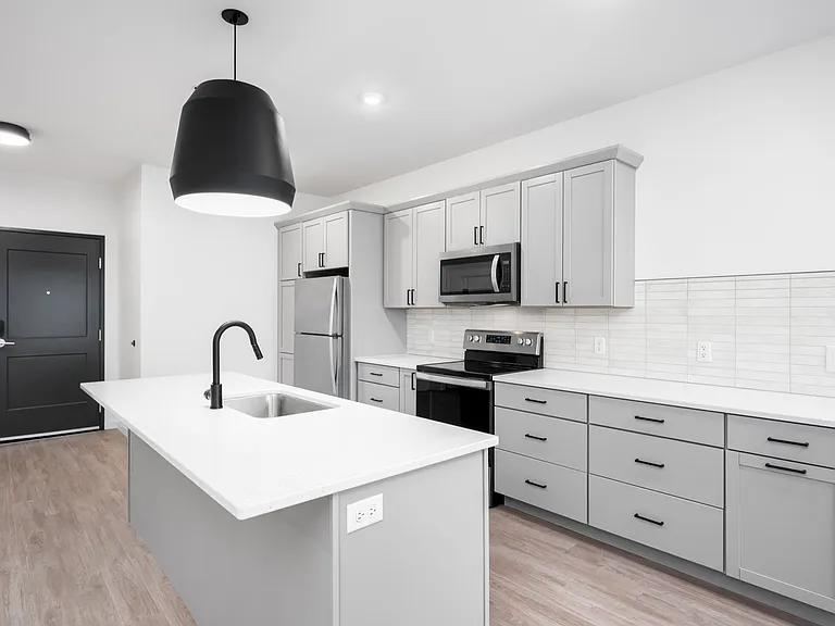 Modern kitchen with sleek gray cabinetry, stainless steel appliances, and stylish pendant lighting. Modern kitchen with sleek gray cabinetry, stainless steel appliances, and stylish pendant lighting.