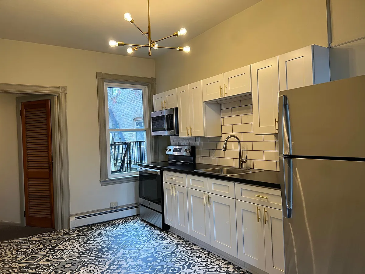 Kitchen has stainless steel appliances: full sized refrigerator, microwave, and electric range. - 25 S West End Ave #2
