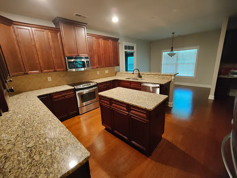 Large kitchen with breakfast area and window to back porch behind.