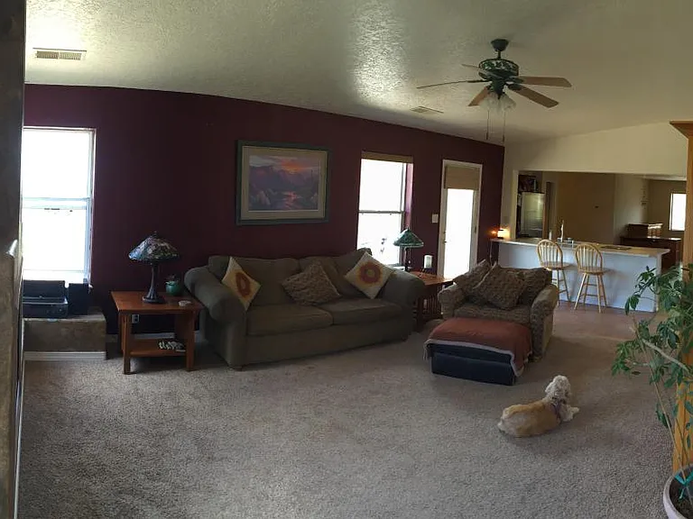 Looking from master bedroom doorway into family room, kitchen, den, entryway, & 3 more bedrooms & 2 baths.