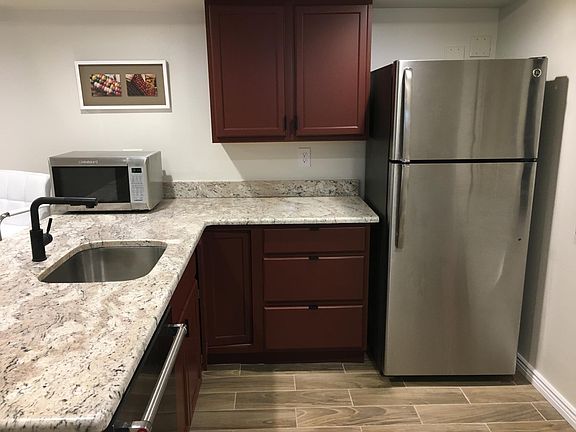 Enter into Kitchen area. Freezer/Refrigerator combo, microwave/convection oven, and dishwasher under granite counter top.