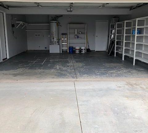 Two car garage with washer and dryer hook ups at the back left side of garage.
Garage door leading to house and a door leading to backyard.