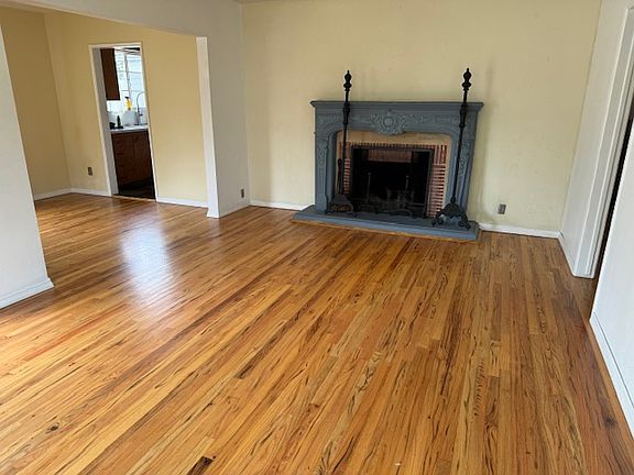 Living room, dining room area with hand-tinted 1940's original solid oak plank wood flooring recently refinished.