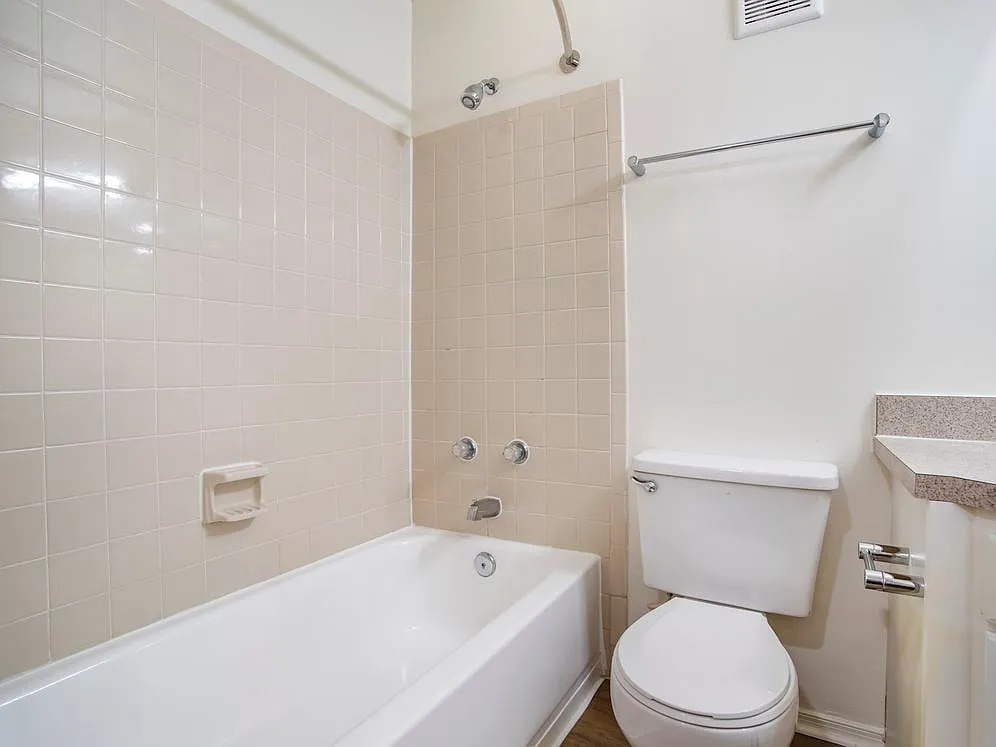 Renovated Package II bath with laminate countertops, white cabinetry, and hard surface flooring - eaves Fair Lakes