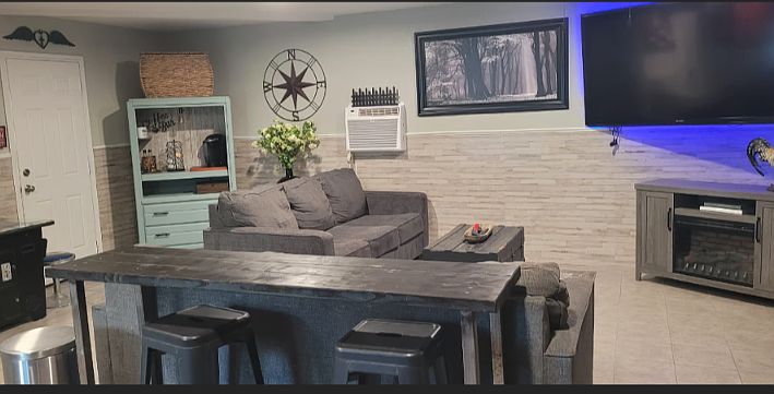 Living area with tiled floors and huge TV. Laundry available, private bathroom and gated entry. Living space is approx 950 square feet