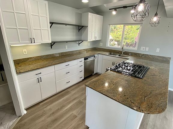 Large Kitchen with plenty of countertop space, new Samsung Gas Cooktop and Oven, newly painted cabinets, lights, walk-in pantry and floating shelves.