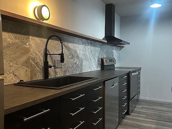 Large format backsplash tile + a wide, single basin kitchen sink with articulating faucet for easy cleanup.
