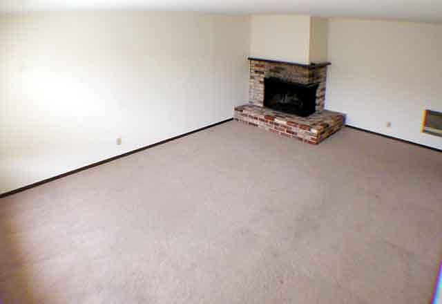 Living room with wood-burning fireplace (new flooring not pictured)
