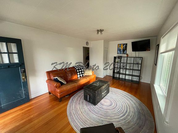 Front door enters to bright living room with refinished hardwood floors