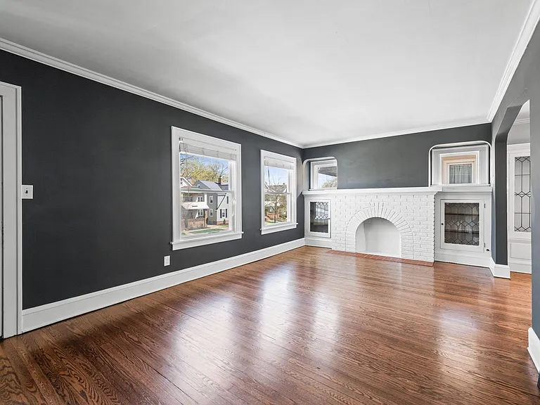 This photo showcases the decorative fireplace, built-ins, and the door leading to the sunroom.