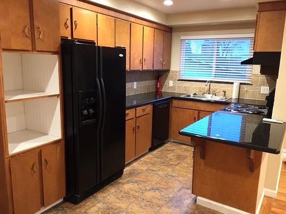 Kitchen with granite counters, newer appliances and stainless sink.