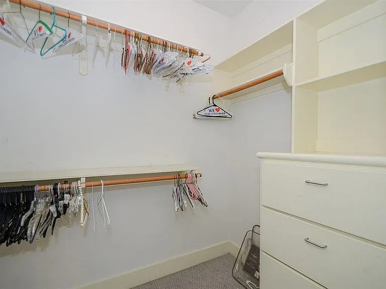 Over-sized walk in closet with built in shelving and drawers
