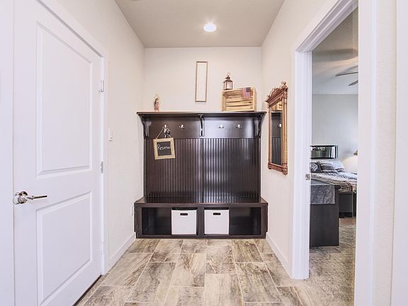 1st floor mud room with installed coat/hat hooks and room for storage. Garage access.