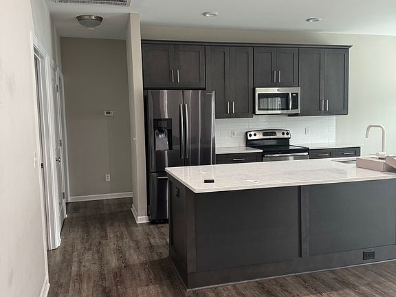 Standing at front door looking at kitchen and down hall to 2 bedrooms and bath