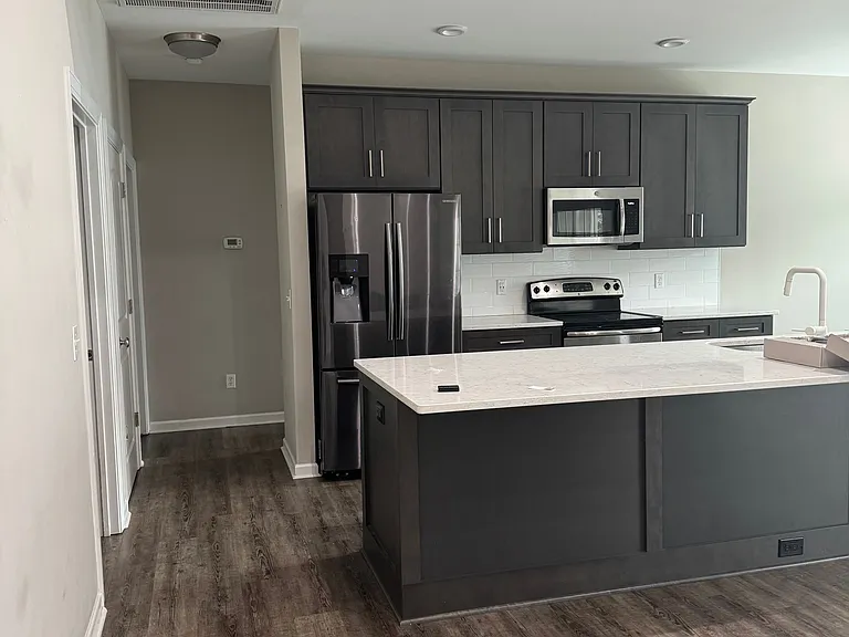 Standing at front door looking at kitchen and down hall to 2 bedrooms and bath
