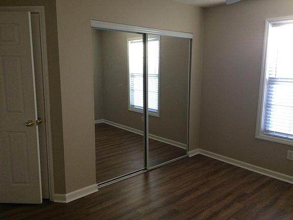 Master bedroom with mirrored closet doors.