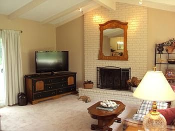 The living room has a fireplace, vaulted ceiling and a sliding glass door to the backyard. The living room window is new.