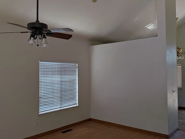Living and dining area with window, and walkway to Kitchen and family room and backyard door.