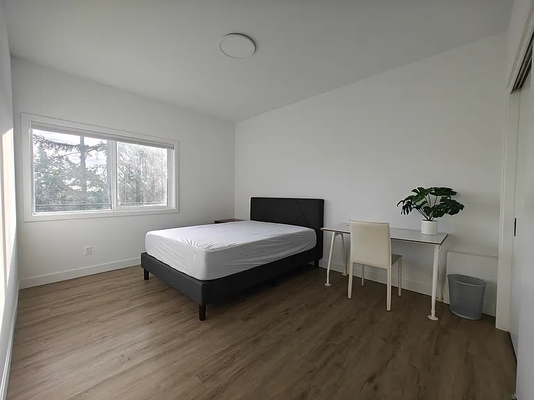 Larger bedroom with queen size bed and desk. Has a view of Lake Washington.