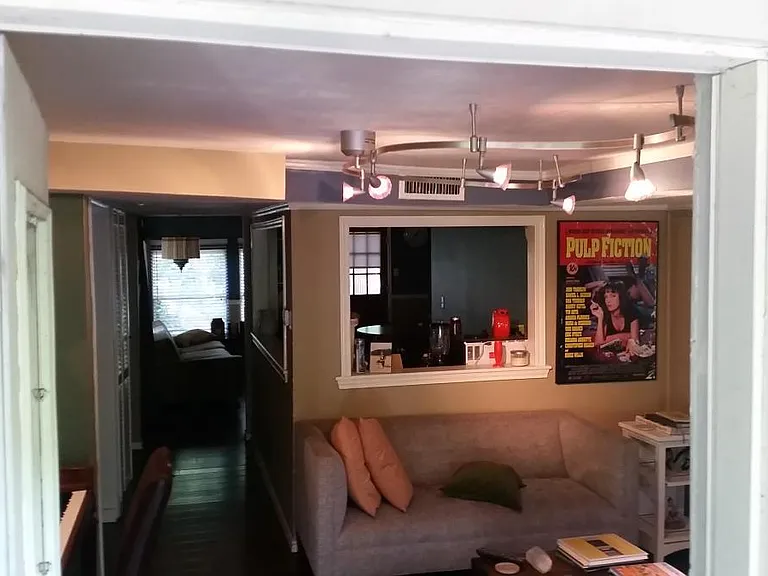 Older photo as a previous tenant had it decorated. View from the front door (Rm #1). Kitchen is in middle with back room (Rm #2) viewable. Bedroom (Rm #3) located to the left, opposite the efficiency kitchen.