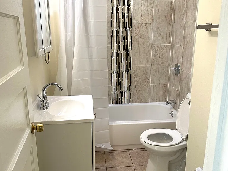 Remodeled and modern ceramic tile bath with skylight