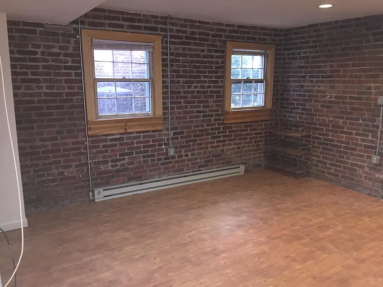 Downstairs in-law suite view of area to put beds or couches features exposed brick walls.