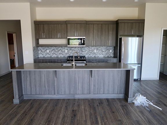 front door is down the hallway to the left. This view is standing by back sliding doors and looking at the open kitchen. pantry is to the right