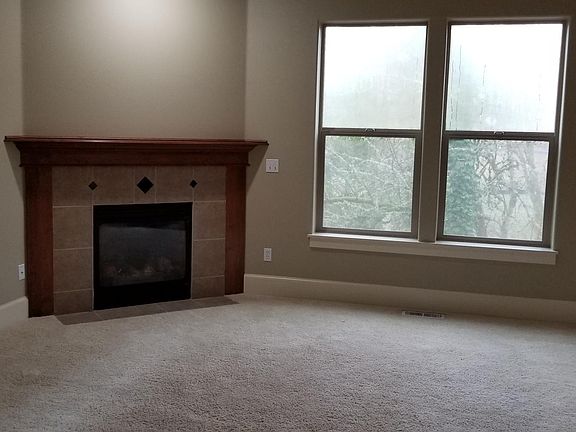 Family room with gas fireplace view to green belt