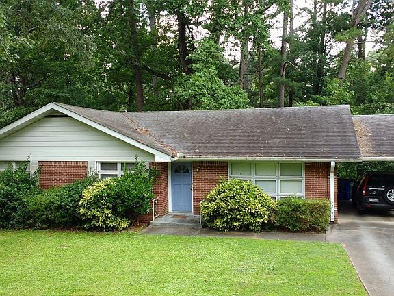 Front of house with car port.