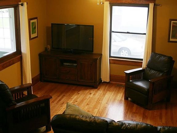 Spacious living room with wood floors
						:
						Shot from the elevation of the open, matching wood staircase