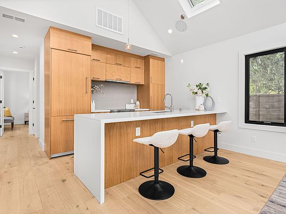 Kitchen with barstools; hallway to the bedroom and bathroom is on the left