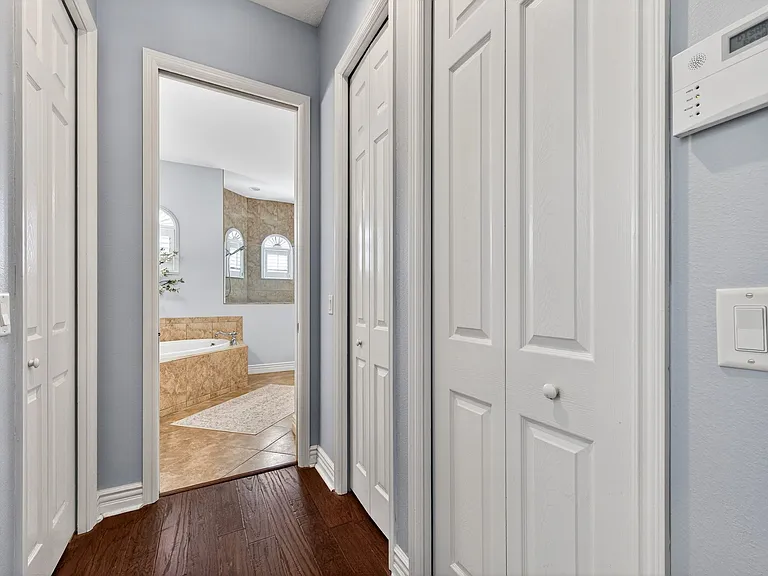 His and hers walk-in closets on opposite sides of the hallway along with a linen closet