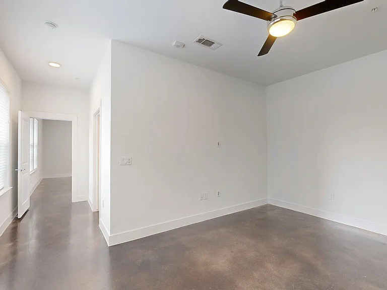 Spacious apartment bedroom with large closet and polished concrete flooring.