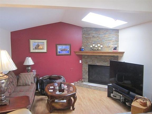 Dramatic living room...gas fireplace, vaulted ceiling, skylight, new laminate floors throughout.