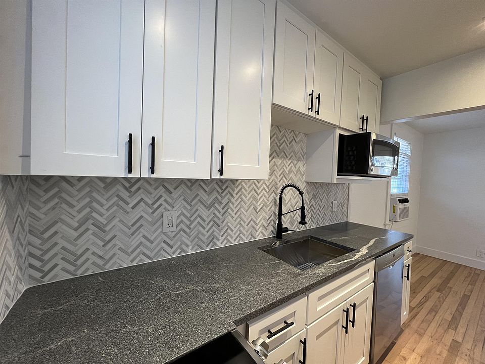 Kitchen has new slow close white shaker cabinets &herringbone marble backsplash