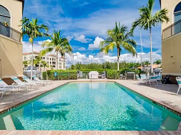 Take the plunge! Inviting heated pool and barbecue grill area overlook sailboat turning basin and channels beyond.